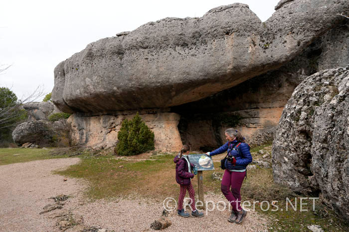 Frente a un panel informativo en La Ciudad Encantada
